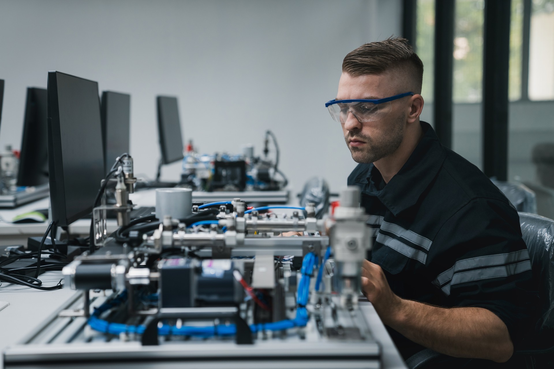 Etudiant ingénieur Assemblage Bras Robotique avec ordinateur dans l’Atelier Technologique. Ingénieur de service tenant le contrôleur de robot et vérifiant le matériel de soudage de bras robotique.