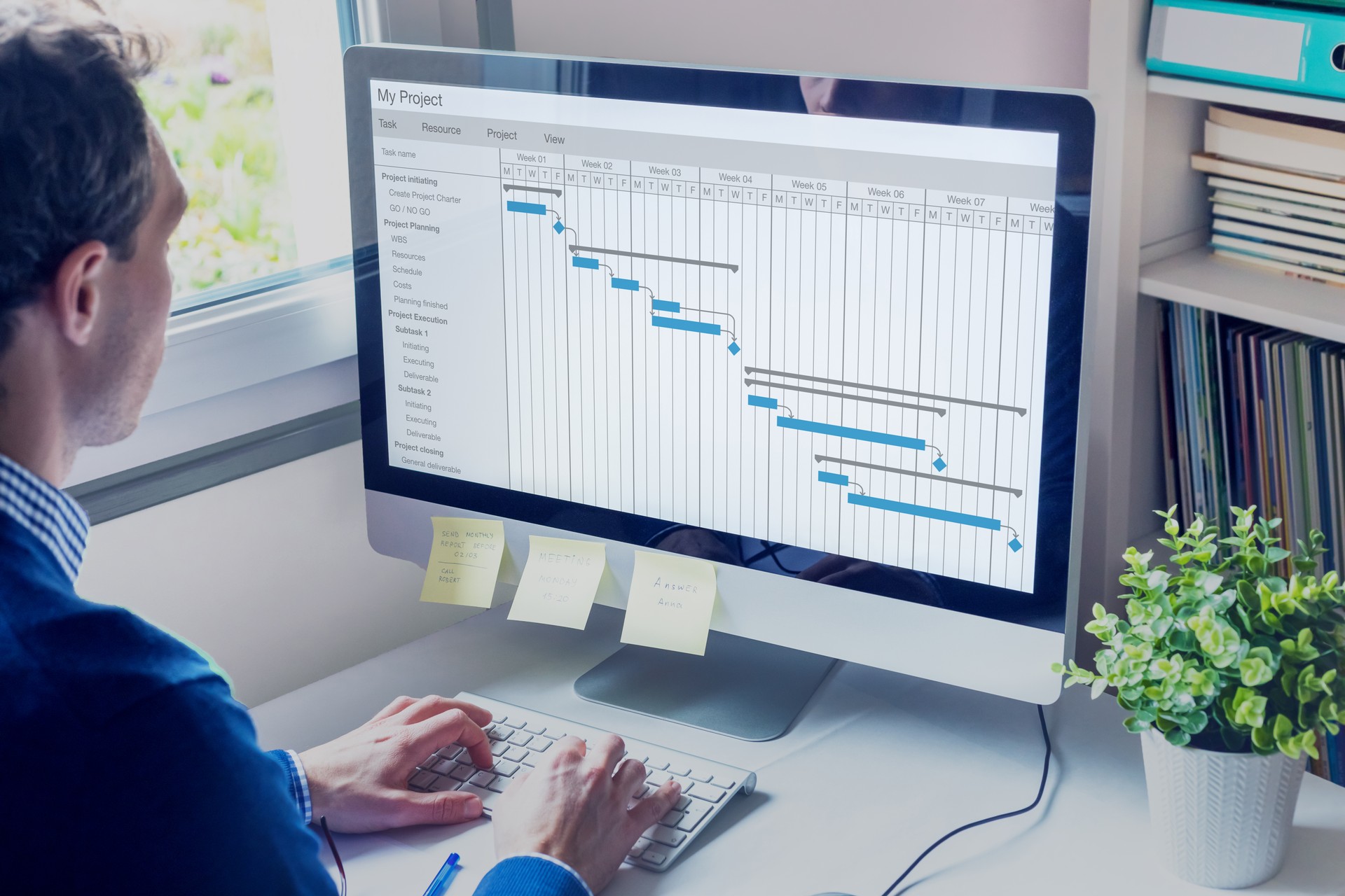 Gestionnaire de projet travaillant sur le calendrier des cartes de Gantt pour créer la planification avec des tâches et des jalons pour planifier des activités, la personne travaillant avec des outils de gestion sur l'ordinateur au bureau